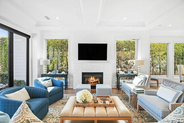 sunroom / solarium featuring visible vents, beamed ceiling, a glass covered fireplace, and a wealth of natural light