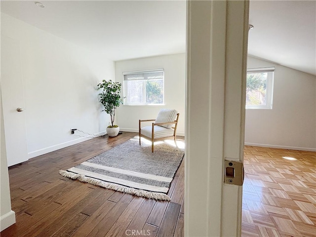 living area with lofted ceiling, parquet flooring, baseboards, and a wealth of natural light