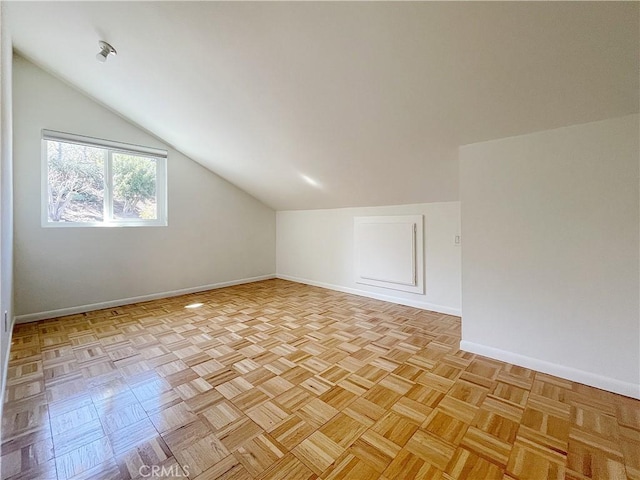 additional living space featuring vaulted ceiling and baseboards