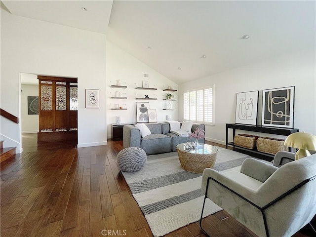 living area featuring stairway, baseboards, high vaulted ceiling, and dark wood finished floors