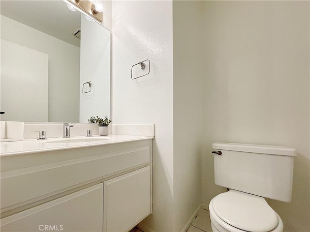 bathroom featuring vanity, toilet, and baseboards