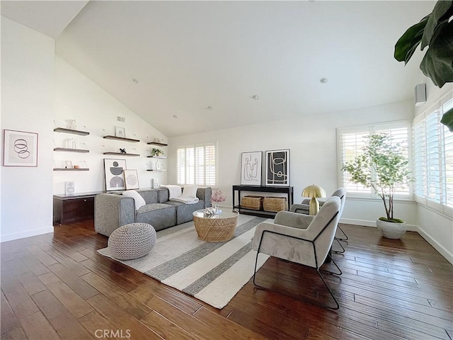 living area with dark wood-style floors, high vaulted ceiling, a wealth of natural light, and baseboards