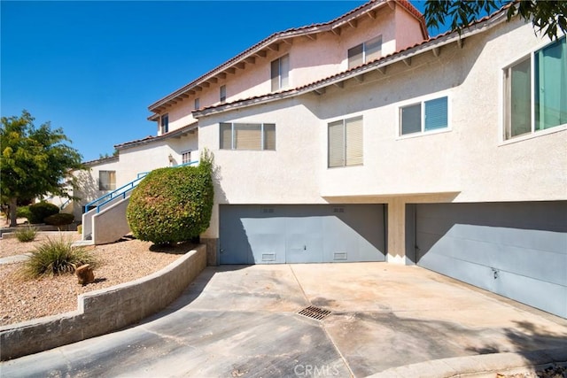 mediterranean / spanish house with a garage, driveway, and stucco siding