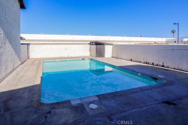 view of swimming pool featuring a patio area, fence, and a fenced in pool