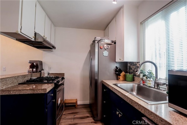 kitchen with a wealth of natural light, gas stove, a sink, and tasteful backsplash