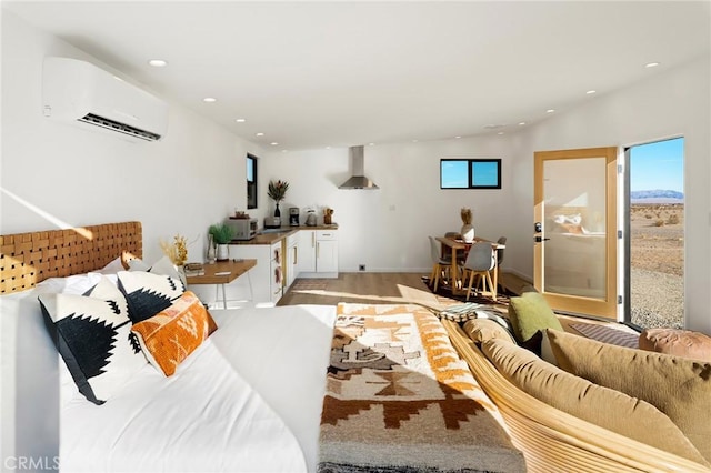 living area featuring a healthy amount of sunlight, light wood-type flooring, an AC wall unit, and recessed lighting