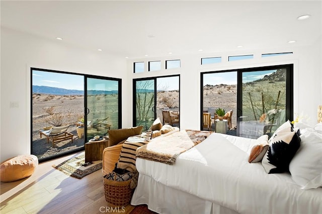 bedroom featuring access to exterior, multiple windows, wood finished floors, and recessed lighting