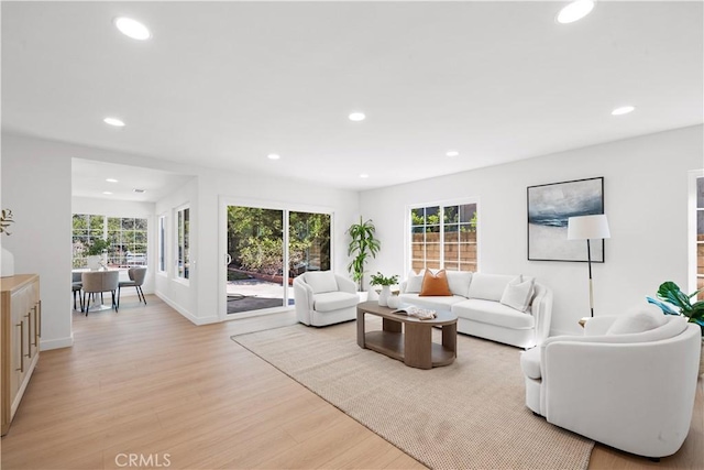 living area featuring a wealth of natural light, recessed lighting, and light wood-style flooring