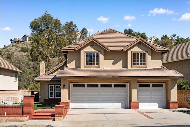 view of front facade featuring fence, a tiled roof, and stucco siding