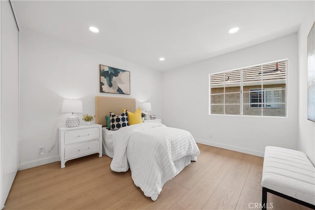 bedroom featuring light wood finished floors, baseboards, and recessed lighting