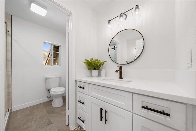 bathroom featuring baseboards, vanity, and toilet