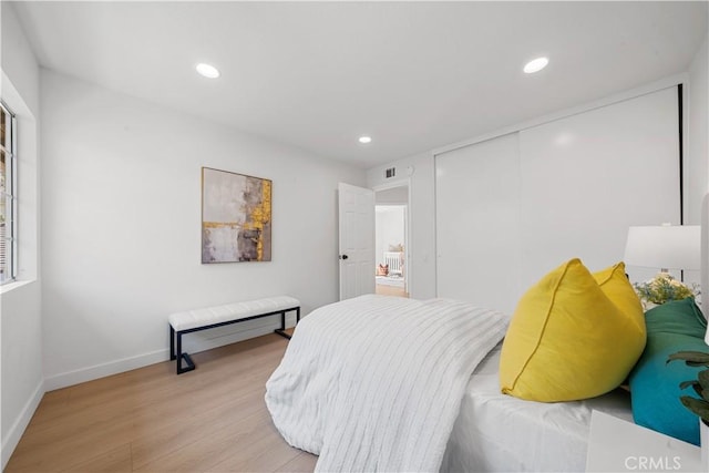 bedroom featuring light wood-style flooring, recessed lighting, visible vents, baseboards, and a closet