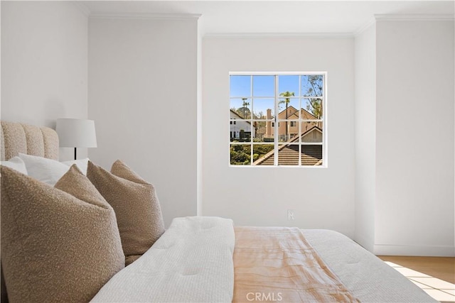 bedroom featuring ornamental molding and wood finished floors