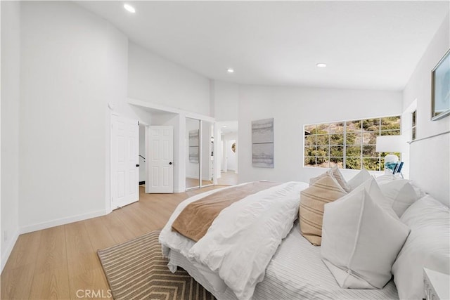 bedroom with light wood-type flooring, lofted ceiling, baseboards, and recessed lighting