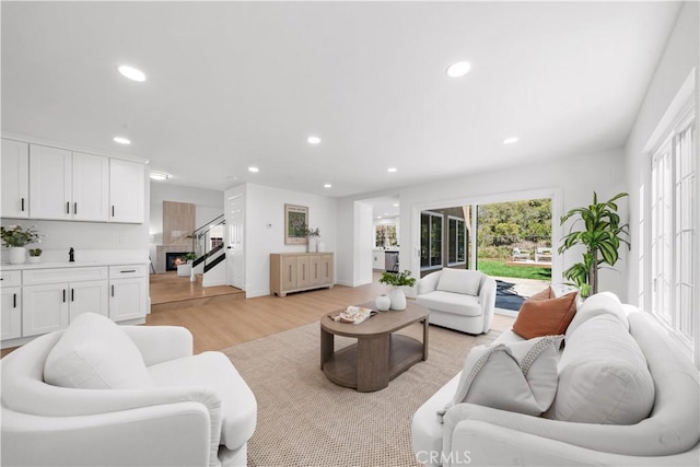 living area featuring recessed lighting, plenty of natural light, and light wood-style flooring