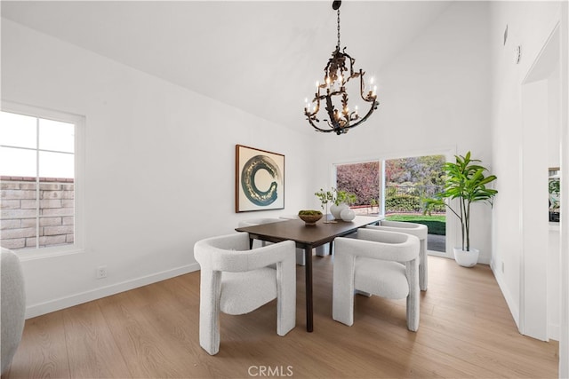 dining area featuring a chandelier, light wood finished floors, plenty of natural light, and baseboards