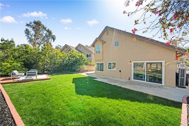 back of house with a yard, a patio area, fence, and stucco siding