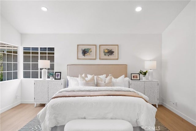 bedroom featuring baseboards, wood finished floors, and recessed lighting