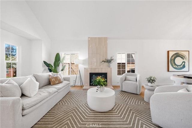 living area with plenty of natural light, a fireplace, and vaulted ceiling