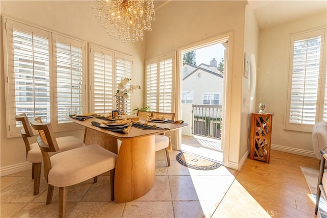 dining room featuring baseboards, a wealth of natural light, and a notable chandelier