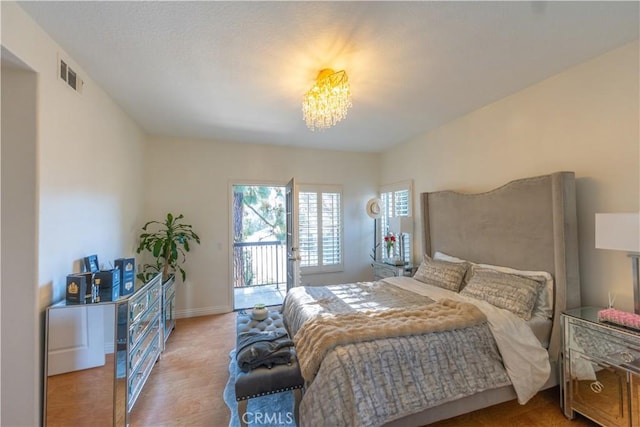 bedroom featuring visible vents, baseboards, and wood finished floors