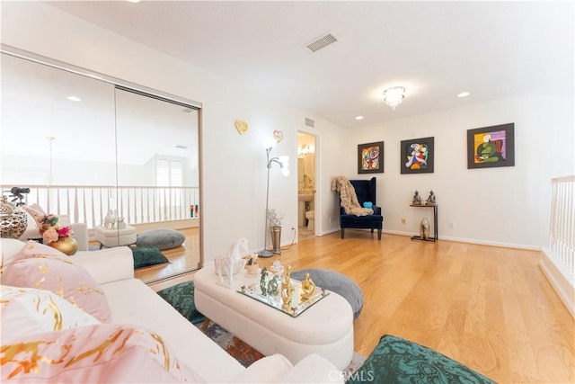 living area featuring recessed lighting, visible vents, baseboards, and wood finished floors