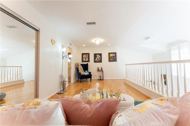 living area with light wood-style floors and visible vents