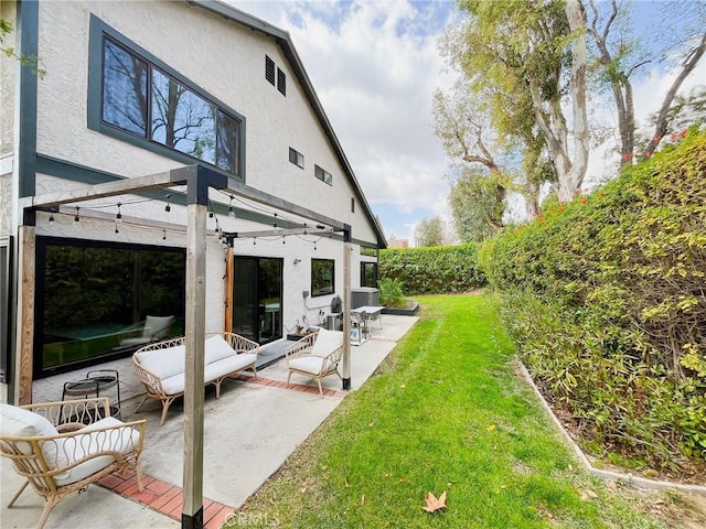 back of house with a lawn, a patio area, a fenced backyard, and stucco siding