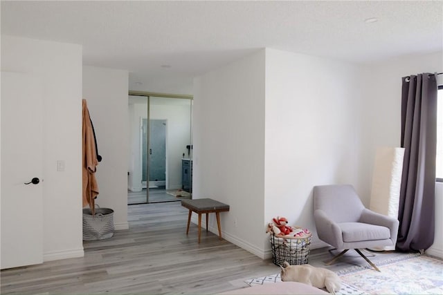 living area with light wood-style floors and baseboards