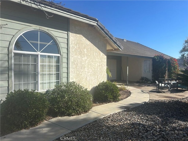 view of home's exterior with a patio and stucco siding