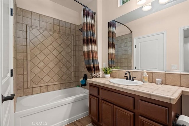 bathroom with visible vents, vanity, and shower / bath combo with shower curtain