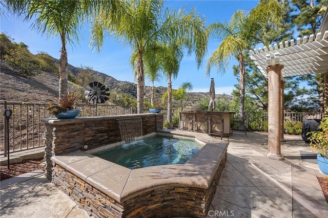 view of pool featuring a patio, a mountain view, fence, outdoor dry bar, and a pergola