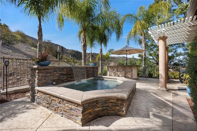 view of patio with exterior bar, fence, a mountain view, and a pergola