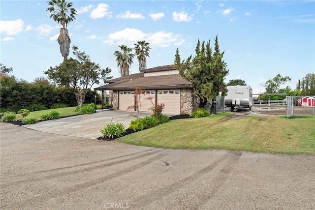 view of front of property with a garage, stone siding, a front lawn, and driveway