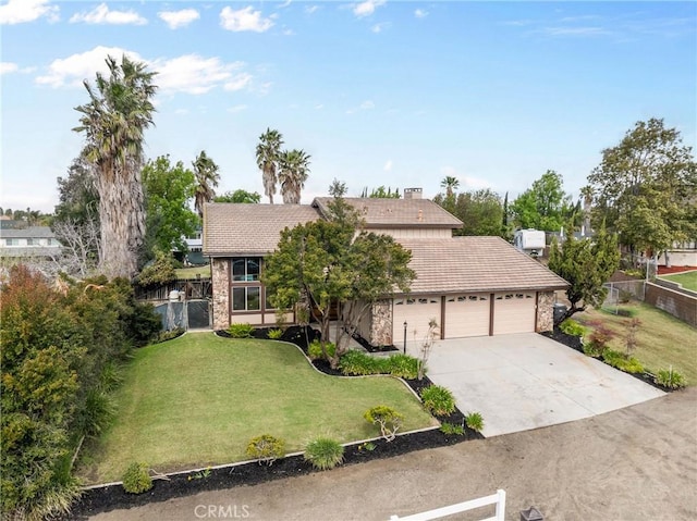 view of front of property with a garage, concrete driveway, a front yard, and fence