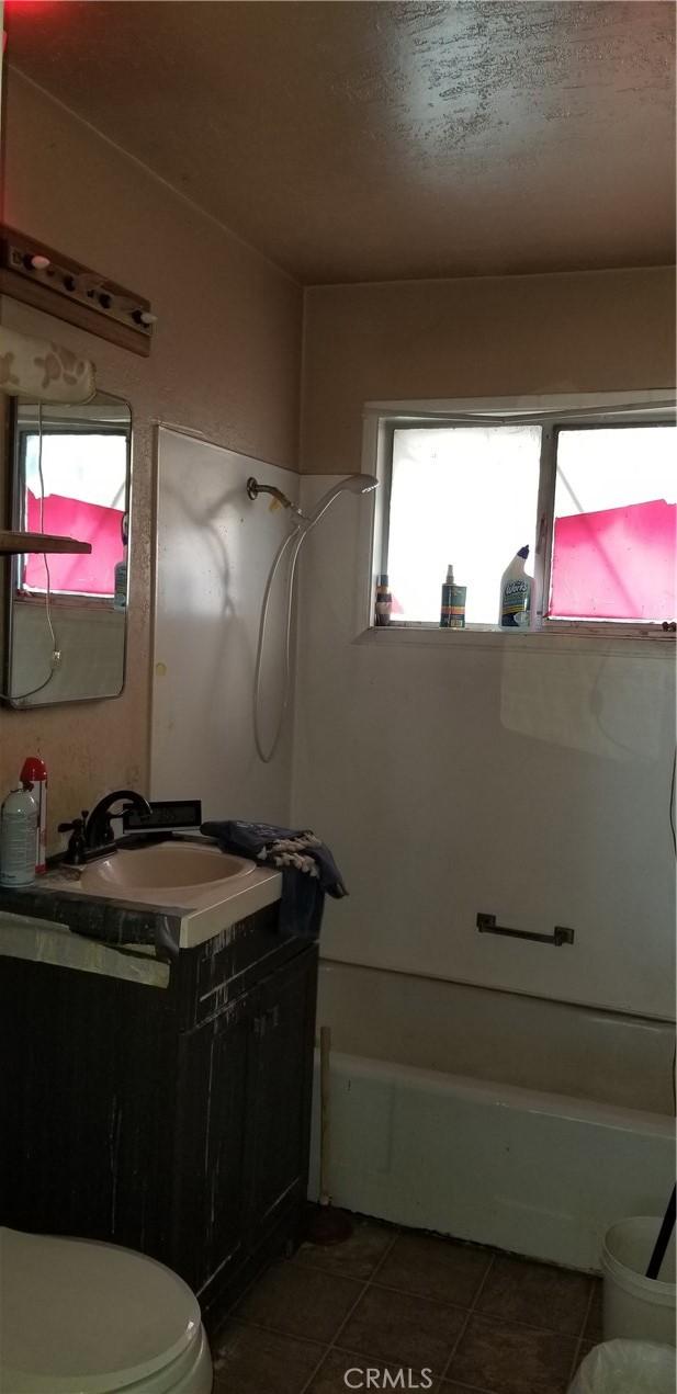 bathroom featuring toilet, tile patterned flooring, and vanity