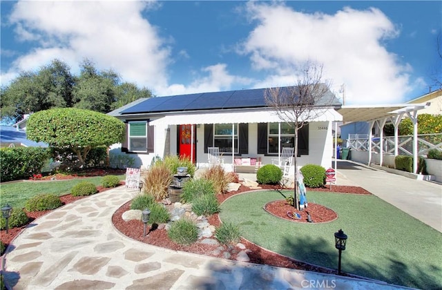 view of front of home featuring a carport, covered porch, a front lawn, and concrete driveway