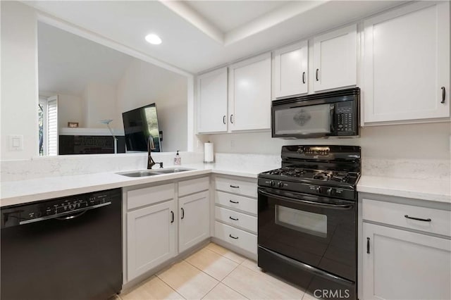 kitchen featuring white cabinetry, a sink, black appliances, and light tile patterned floors