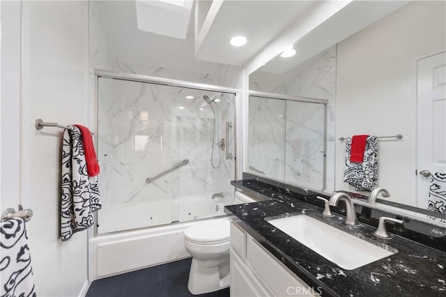 bathroom featuring enclosed tub / shower combo, toilet, and vanity