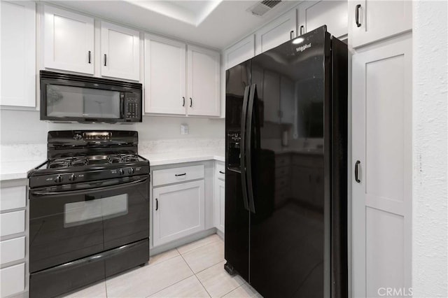 kitchen featuring light tile patterned floors, visible vents, white cabinets, light countertops, and black appliances