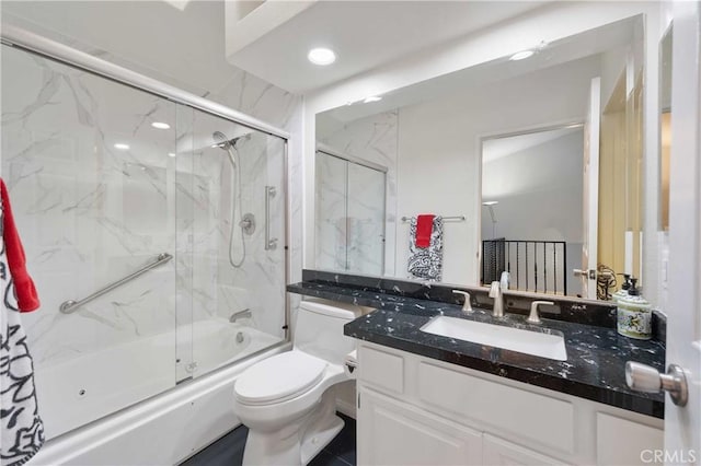 full bath featuring toilet, shower / bath combination with glass door, and vanity