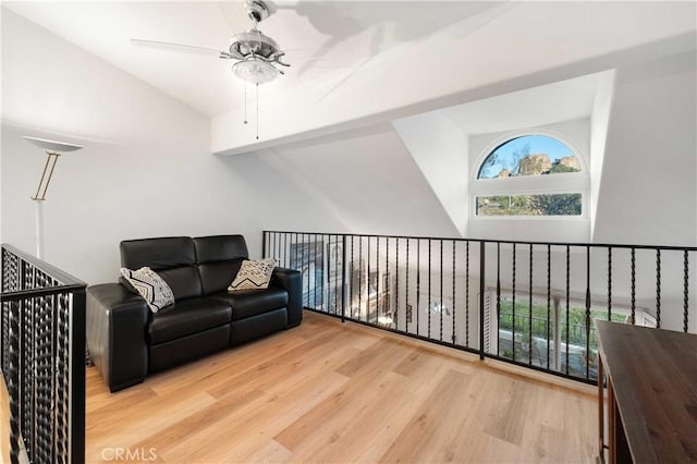 living area with lofted ceiling, plenty of natural light, a ceiling fan, and light wood-style floors