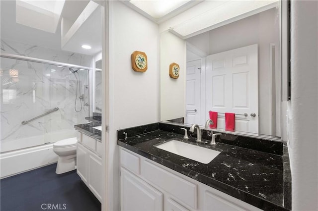 full bathroom with toilet, a marble finish shower, and vanity