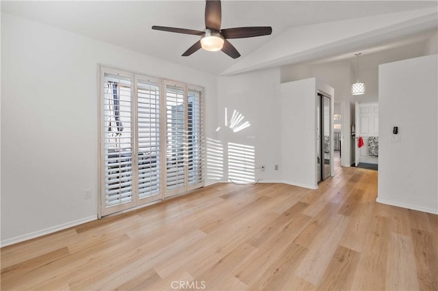 empty room with light wood-style flooring, baseboards, vaulted ceiling, and a ceiling fan