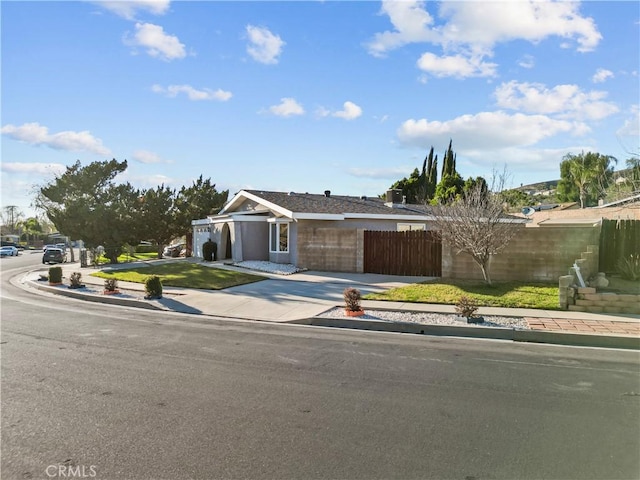 view of front of property featuring driveway and fence