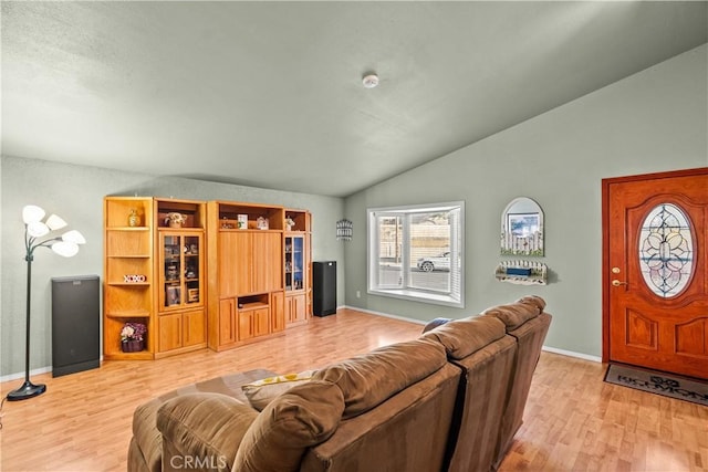 living area with lofted ceiling, light wood-style floors, and baseboards