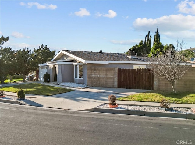 view of front of home with an attached garage, fence, concrete driveway, and stucco siding