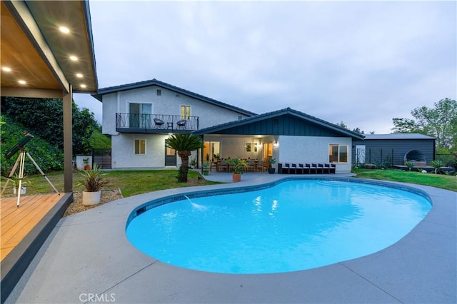 outdoor pool with a yard and a patio