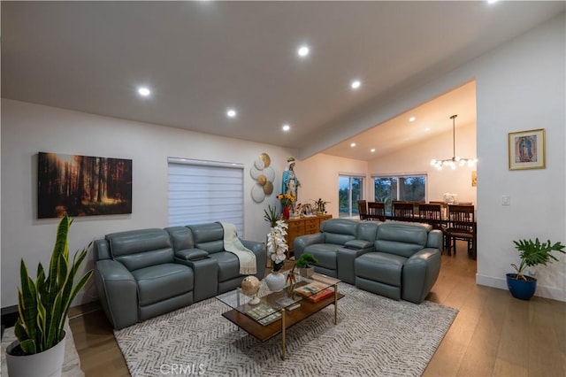 living area with lofted ceiling, a notable chandelier, light wood-style flooring, and recessed lighting