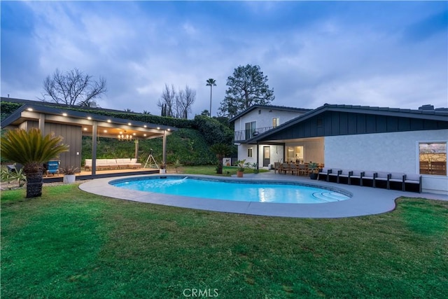 outdoor pool with a lawn and a patio area